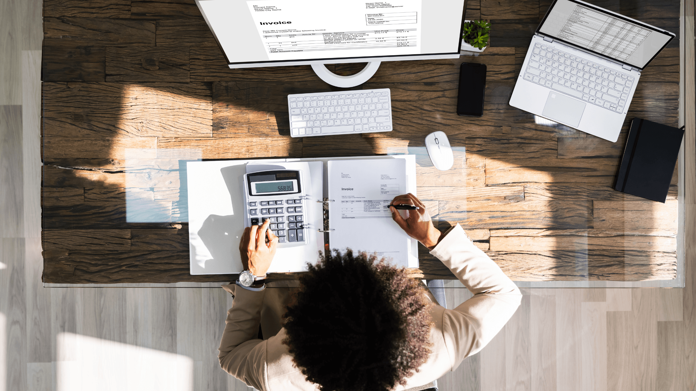 Personne travaillant sur sa comptabilité freelance à un bureau avec ordinateur et documents